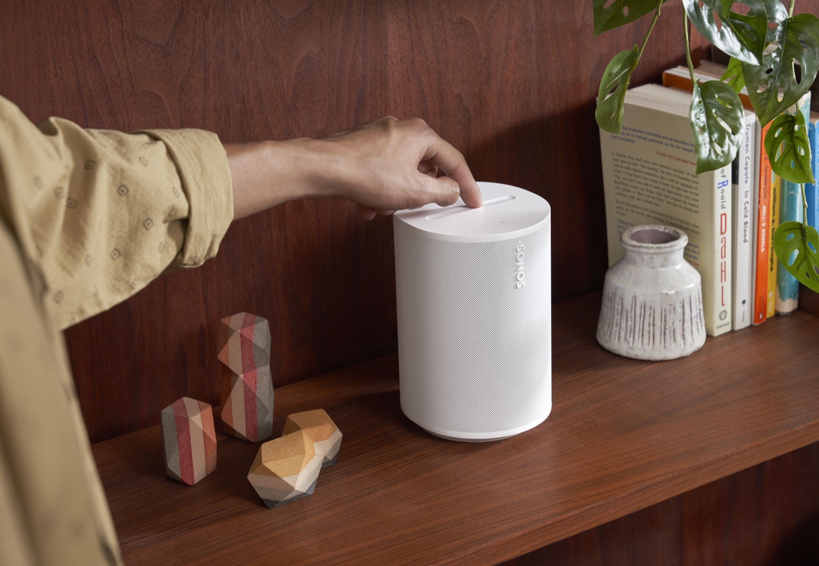 Sonos Era 100-højttaler på en hylde i et hjem